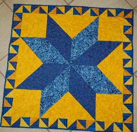 A blue and yellow quilt on a tile floor

Description automatically generated with medium confidence