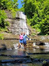 Two women standing in front of Buttermilk Falls State Park

Description automatically generated