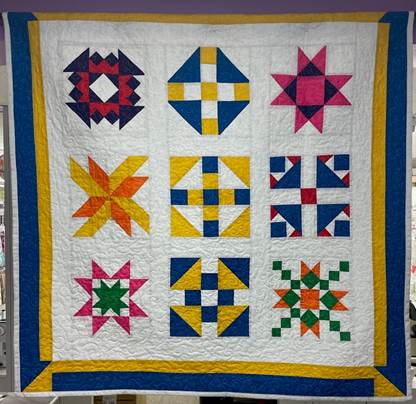 A quilt with different colors of quilting

Description automatically generated