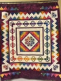 A colorful quilt with a diamond and triangles