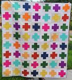A colorful quilt with different colored crosses

AI-generated content may be incorrect.