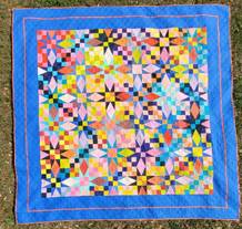 A colorful quilt on grass

AI-generated content may be incorrect.