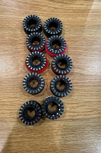 A group of black and red objects on a wood surface

AI-generated content may be incorrect.